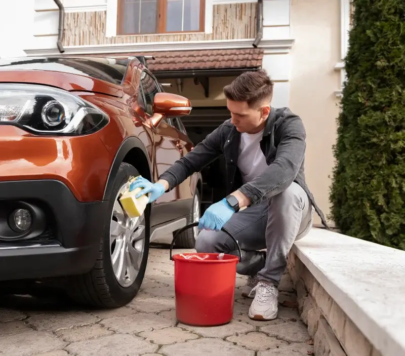 Lavage auto à domicile Parigné-l'Évêque : professionnel intervenant sur un véhicule